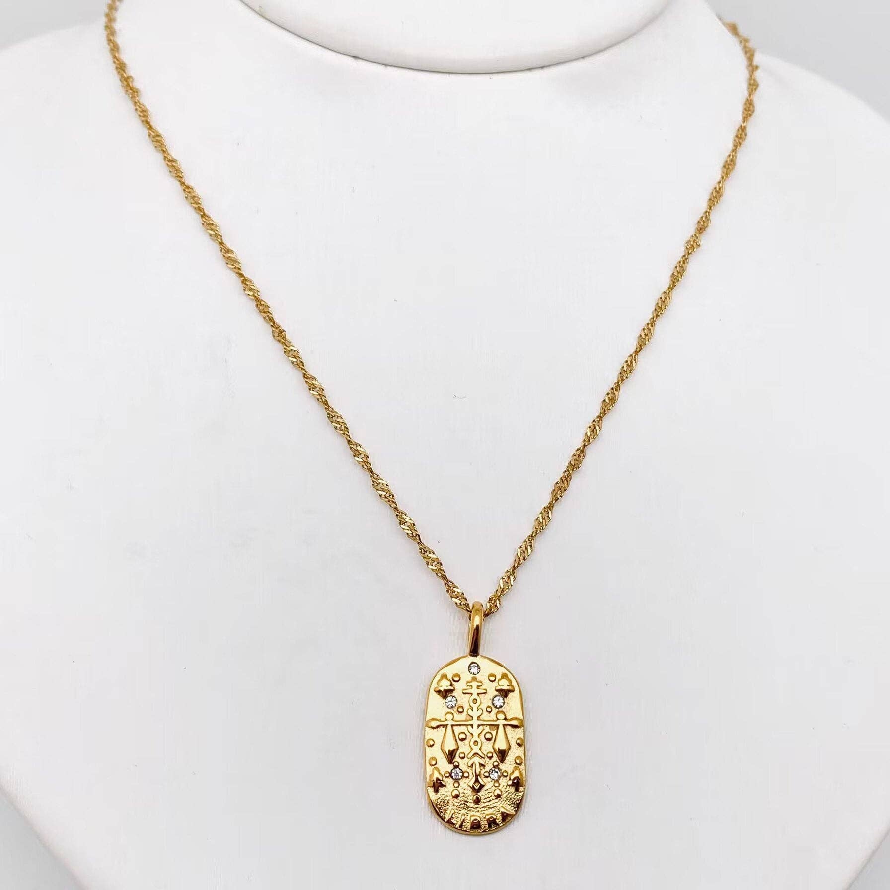 Gold Libra necklace with a detailed pendant on a white background