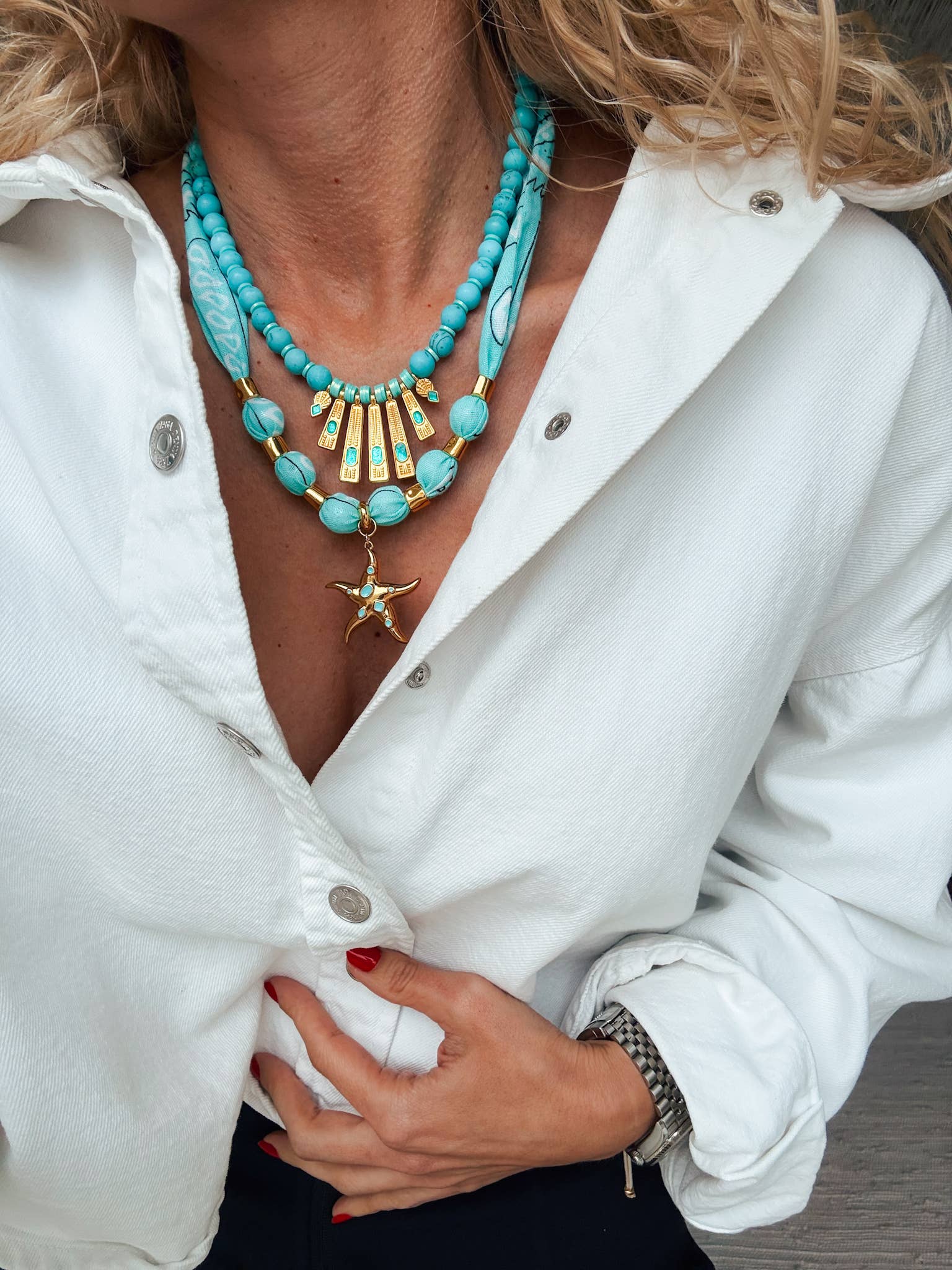 Turquoise-blue beaded necklace with a gold fan pendant and starfish charm.
