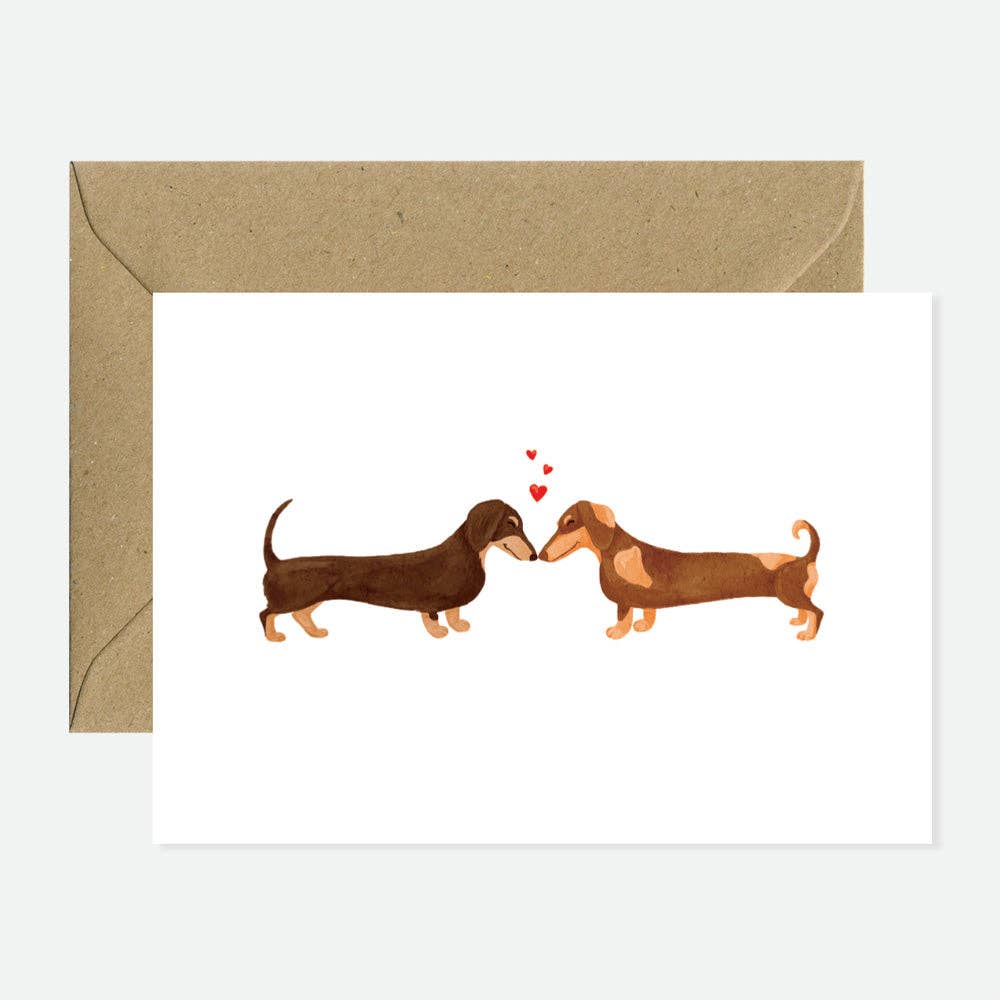 Greeting card with two dachshunds and a heart on a white background with a brown envelope.