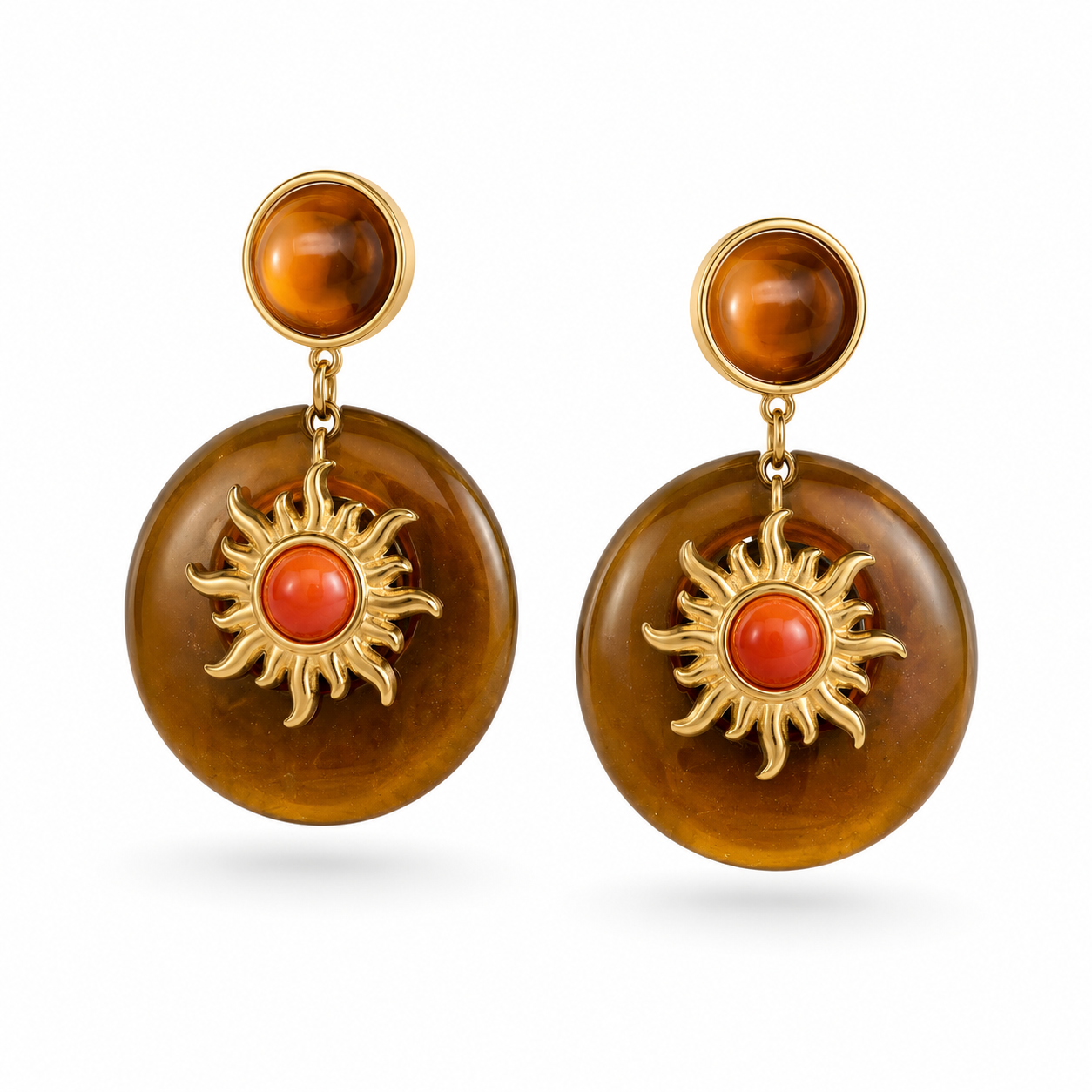 Pair of earrings with orange circular stones and gold sun designs on a white background