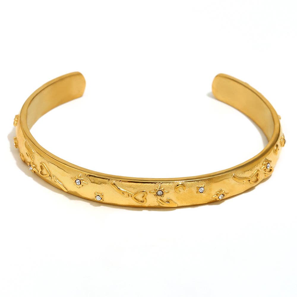Tarot-inspired gold-plated cuff bangle in stainless steel with symbolic engraved detailing and an open sculptural design.