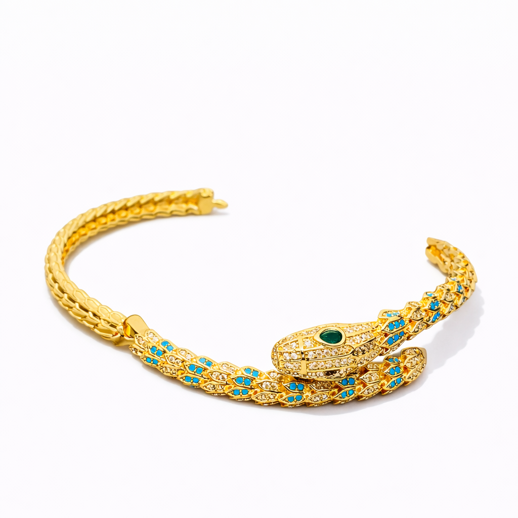 Gold snake-shaped bracelet with green and blue gemstones on a white background