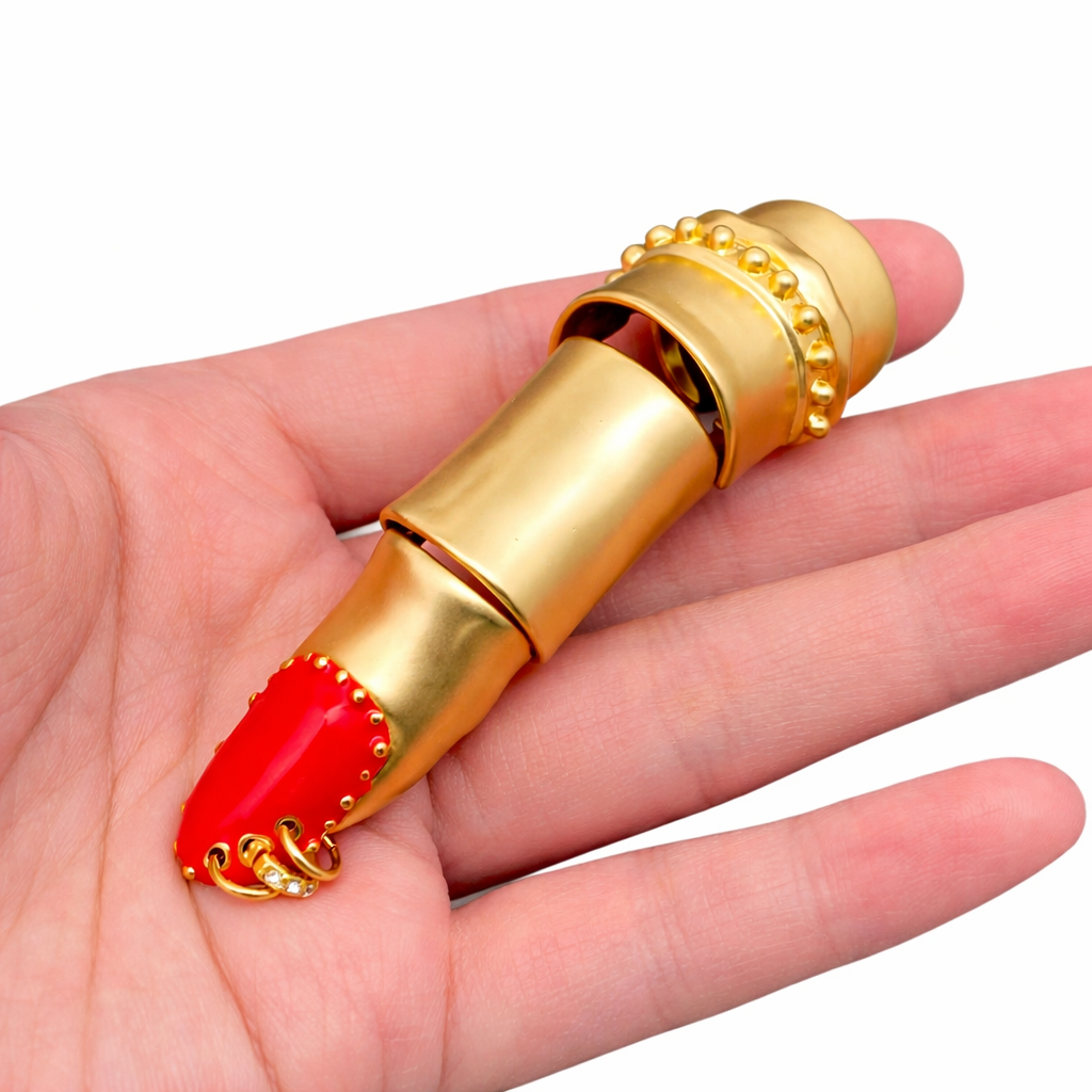 Sculptural gold-plated statement ring with movable segmented design and bold red detailing.